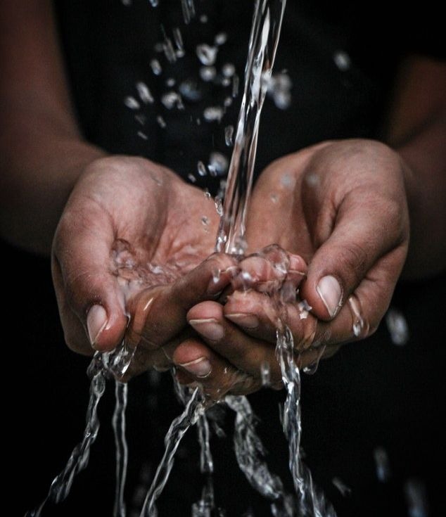 Une femme prenant l'eau dans ses mains