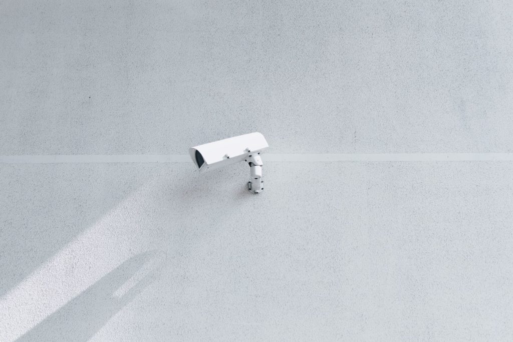 Caméra de vidéosurveillance sur le mur d'un grand bâtiment.